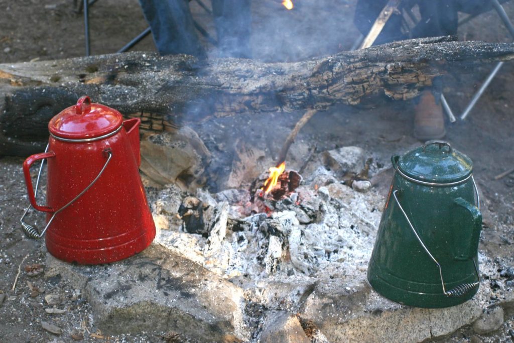 Cowboy coffee making with kettle and campfire