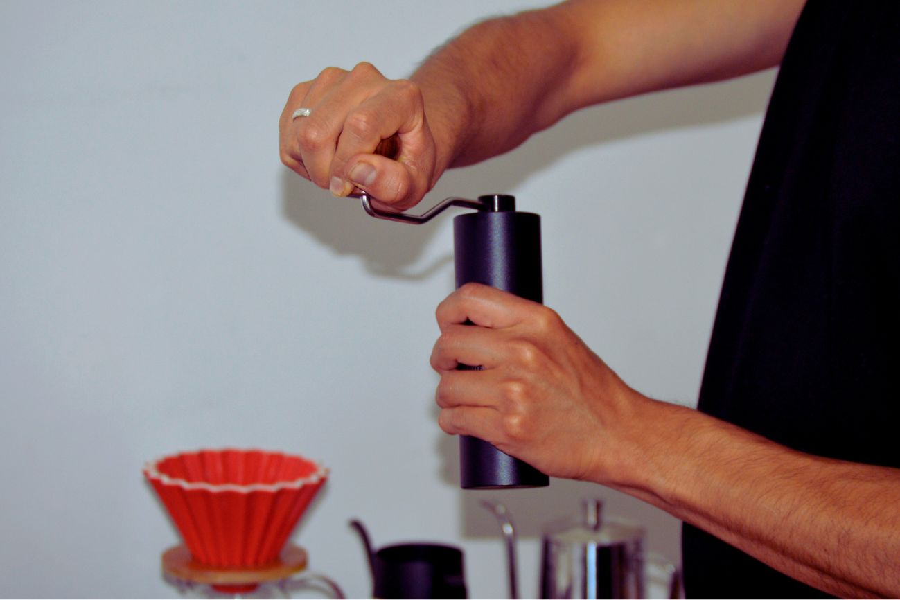 Best burr grinder for pour over coffee next to a dripper on a home kitchen counter
