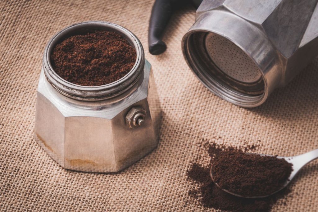 Best coffee beans for moka pot brewing next to a stovetop moka pot and freshly brewed cup of coffee