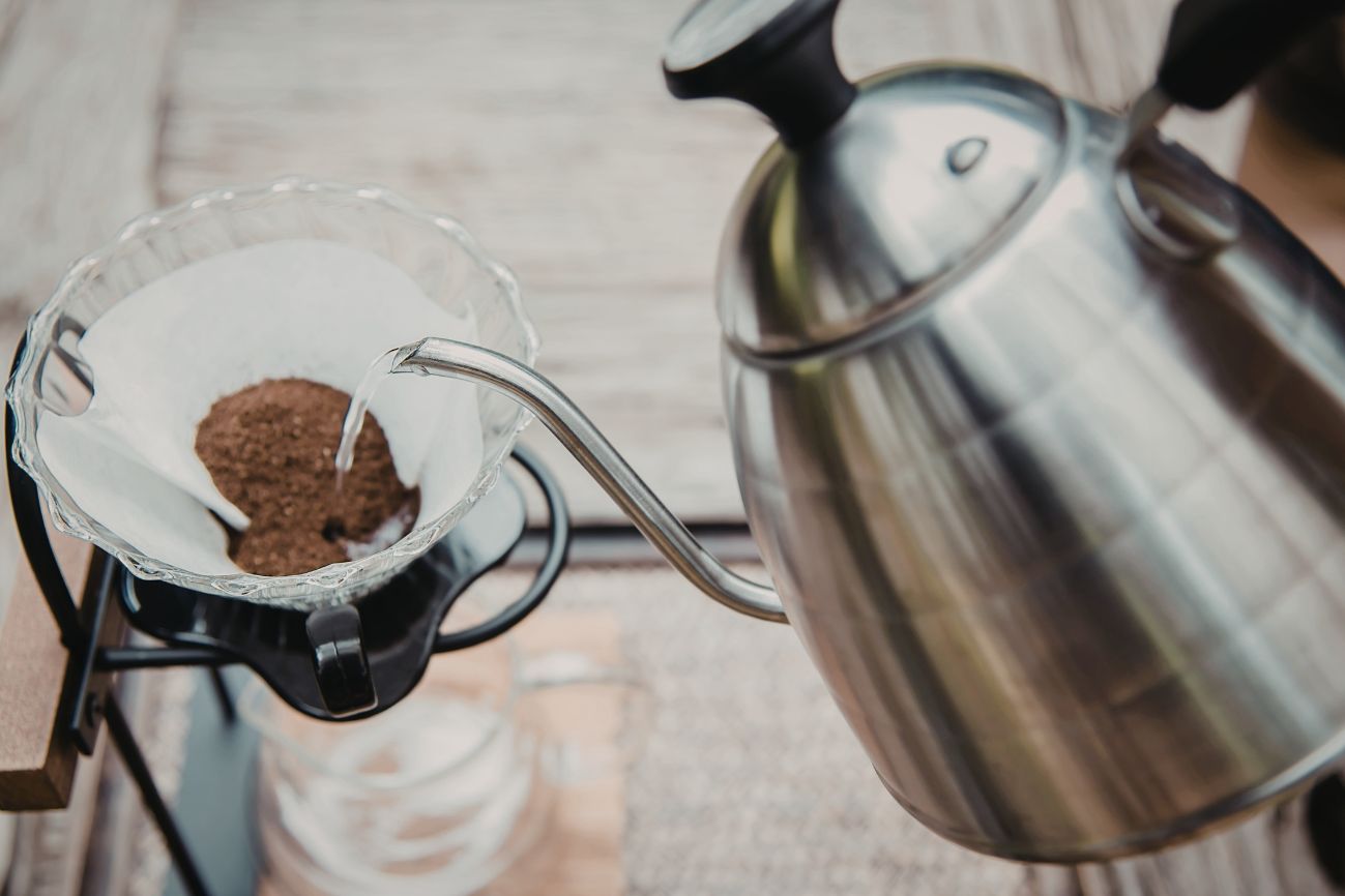 Gooseneck kettle pouring over water to pour over dripper